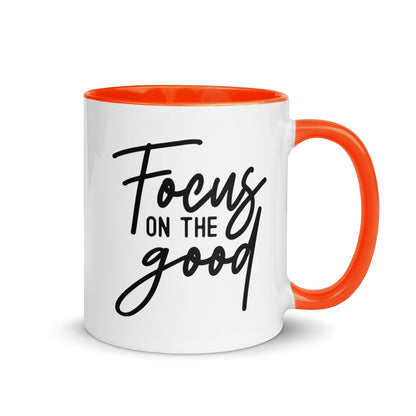 Brewtiful Sips white ceramic mug with orange interior and handle featuring the black text Focus On The Good