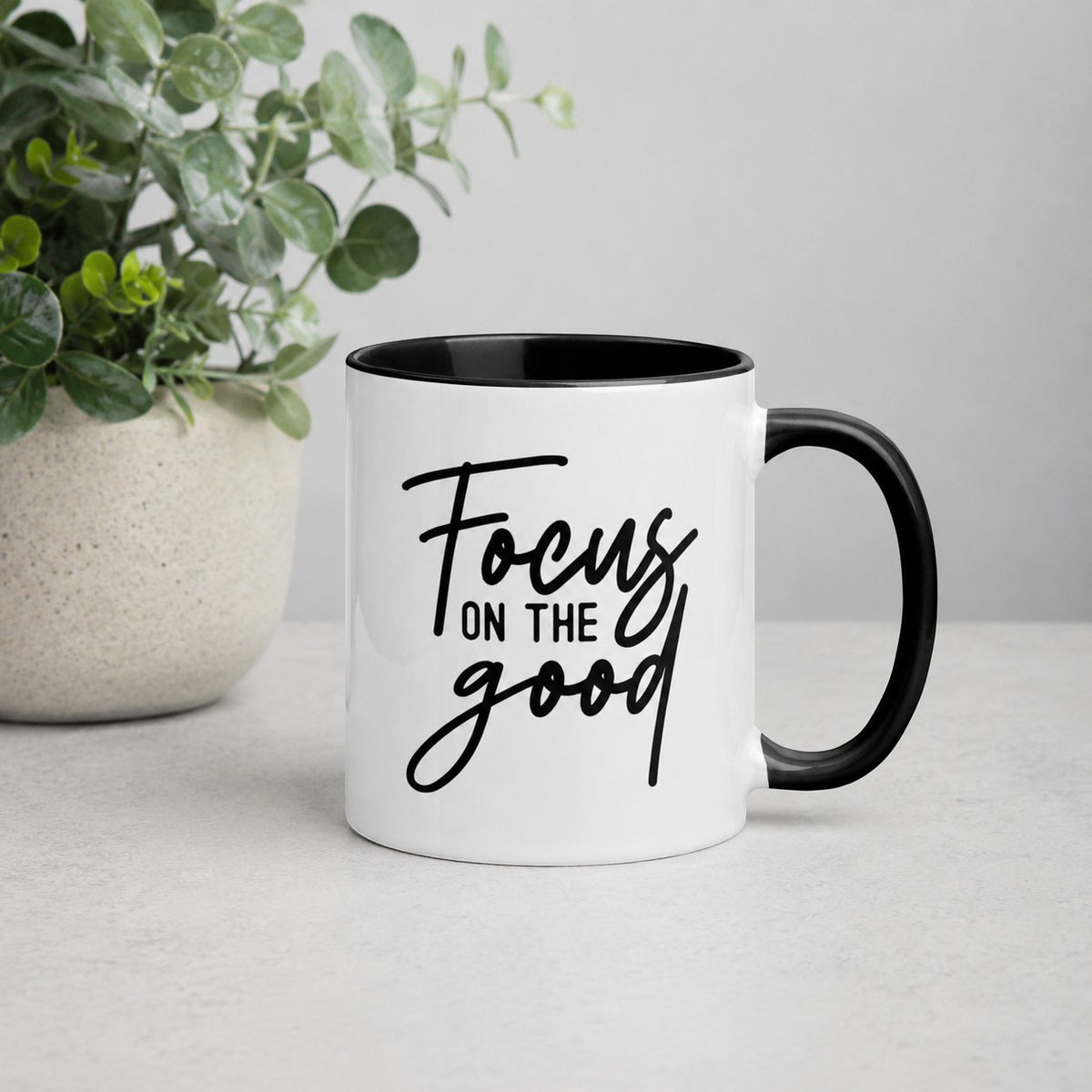 Brewtiful Sips ceramic mug with white exterior, black handle and interior, and Focus On The Good text in black script.